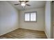 Bright bedroom features wood-look flooring, a ceiling fan, and plantation shutters at 13414 W Maui Ln, Surprise, AZ 85379