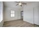 This bedroom features wood-look flooring, a ceiling fan, and plantation shutters at 13414 W Maui Ln, Surprise, AZ 85379