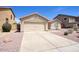 Single-story home features a two-car garage, desert landscaping, and a concrete driveway at 13414 W Maui Ln, Surprise, AZ 85379