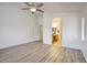 Bright bedroom with wood flooring, ceiling fan, and an ensuite bathroom at 13414 W Maui Ln, Surprise, AZ 85379