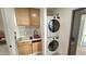 Well-equipped laundry room with stacked washer and dryer, sink, and built-in storage cabinets at 1520 W Encanto Blvd, Phoenix, AZ 85007