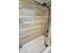 Close-up of tiled shower with modern fixtures, a tub, and neutral-toned tiles extending to the ceiling at 1520 W Encanto Blvd, Phoenix, AZ 85007