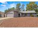 Suburban home with a well-kept lawn, 2-car garage, and mature trees adding to the curb appeal, creating a cozy atmosphere at 16412 N 33Rd Ave, Phoenix, AZ 85053