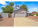 Exterior view showing front yard landscaping, attached two-car garage, and neutral stucco finish in a suburban neighborhood at 16412 N 33Rd Ave, Phoenix, AZ 85053