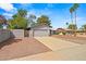 Attractive exterior view featuring desert landscaping, a two-car garage, palm trees, and block wall in a residential neighborhood at 16412 N 33Rd Ave, Phoenix, AZ 85053