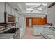 Open-concept kitchen with white cabinets, stainless appliances, and breakfast bar overlooking the adjacent living area at 16412 N 33Rd Ave, Phoenix, AZ 85053