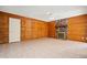 Charming living room with rustic wood paneling, stone fireplace, and tile flooring for easy maintenance at 16412 N 33Rd Ave, Phoenix, AZ 85053