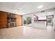 Large living room seamlessly connected to the kitchen, featuring a stone fireplace and sliding glass door at 16412 N 33Rd Ave, Phoenix, AZ 85053