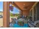 Charming back patio offers seating, a hanging flower basket, and views of the spacious backyard at 16781 S 181St Ln, Goodyear, AZ 85338