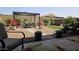 Picturesque backyard with outdoor dining area, lush landscaping, and serene water feature at 16781 S 181St Ln, Goodyear, AZ 85338