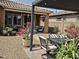 Relaxing covered patio with comfortable seating, surrounded by colorful flowers and desert landscaping at 16781 S 181St Ln, Goodyear, AZ 85338