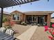 Inviting covered patio with outdoor seating, complemented by lush flower accents and desert landscaping at 16781 S 181St Ln, Goodyear, AZ 85338