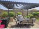 Outdoor dining area with grill, pergola, ambient lights and lush landscape with a dining table at 16781 S 181St Ln, Goodyear, AZ 85338