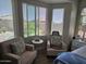 Sitting area featuring natural light and comfortable seating, complemented by serene views from the bedroom windows at 16781 S 181St Ln, Goodyear, AZ 85338