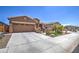 Charming single-story home featuring a two-car garage, manicured landscaping, and a welcoming entrance gate at 16781 S 181St Ln, Goodyear, AZ 85338