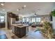 Open-concept kitchen with dark wood cabinetry, stainless steel appliances, and island with granite countertops at 16781 S 181St Ln, Goodyear, AZ 85338