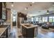 Open concept kitchen with a granite island and stainless steel appliances leading into a cozy living room at 16781 S 181St Ln, Goodyear, AZ 85338