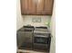 Clean and modern laundry room with wood cabinetry and sleek, gray washer and dryer at 16781 S 181St Ln, Goodyear, AZ 85338