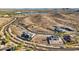 Picturesque aerial view of luxury homes nestled in a desert landscape with a lake and lush green valley in the background at 17837 W Estes Way, Goodyear, AZ 85338