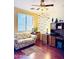 Bedroom featuring hardwood floors, a ceiling fan, and a writing-themed wall decal at 17840 N Smith Dr, Maricopa, AZ 85139