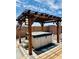 Backyard hot tub beneath a wood pergola, perfect for outdoor relaxation and entertaining at 17840 N Smith Dr, Maricopa, AZ 85139