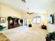 Open living room featuring a ceiling fan, neutral carpet, and a beautiful display cabinet at 17840 N Smith Dr, Maricopa, AZ 85139
