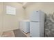 Bright laundry room features a washer, dryer, refrigerator, ironing board and tile flooring at 1813 N Trowbridge --, Mesa, AZ 85207