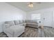 Bright living room with a large comfortable couch and wood-look floors at 1825 W Ray Rd # 2074, Chandler, AZ 85224