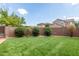 Spacious backyard with artificial turf, shrubbery, and a brick wall fence at 1867 S Seton Ave, Gilbert, AZ 85295