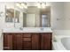 Bathroom with double sinks, brown cabinets, and a large mirror at 1867 S Seton Ave, Gilbert, AZ 85295