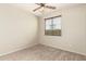 This bedroom features neutral carpet and walls, a ceiling fan, and large window at 1867 S Seton Ave, Gilbert, AZ 85295