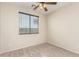 The bedroom is spacious and features neutral carpet and walls and a ceiling fan at 1867 S Seton Ave, Gilbert, AZ 85295