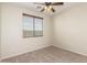 The spacious bedroom has neutral carpet and walls and a nice ceiling fan at 1867 S Seton Ave, Gilbert, AZ 85295