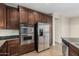 Well-lit kitchen features stainless steel appliances and dark wood cabinetry at 1867 S Seton Ave, Gilbert, AZ 85295