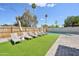 This backyard showcases ample lounge chairs on artificial turf, ideal for enjoying sunny days by the pool at 2045 N 68Th St, Scottsdale, AZ 85257