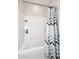 Bright bathroom featuring a shower and tub combination with tiled walls and a chevron shower curtain at 2425 E Beverly Rd, Phoenix, AZ 85042
