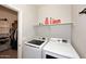 Convenient laundry area featuring modern washer and dryer units with shelving for supplies at 2425 E Beverly Rd, Phoenix, AZ 85042