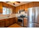 Modern kitchen equipped with stainless steel appliances, wooden cabinets, and tile flooring for a sleek look at 2534 N Mitchell St. St, Phoenix, AZ 85006