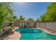 Backyard swimming pool with a small storage building and mature trees, enclosed by a block fence, provides a private outdoor space at 2534 N Mitchell St. St, Phoenix, AZ 85006
