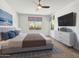 Bright bedroom with neutral decor, featuring a large bed, modern dresser, and a ceiling fan above at 30224 N 52Nd Pl, Cave Creek, AZ 85331