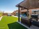 Backyard with artificial grass, outdoor kitchen, hot tub and pergola at 30876 N 128Th Dr, Peoria, AZ 85383