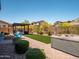 Backyard featuring a fire pit, BBQ area, artificial turf, and a hot tub at 30876 N 128Th Dr, Peoria, AZ 85383
