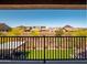 Backyard and community view from a balcony with black metal railings, green grass, and desert landscaping at 30876 N 128Th Dr, Peoria, AZ 85383