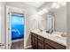 Bathroom with a dual sink vanity and a door to a full bath featuring a shower/tub combination at 30876 N 128Th Dr, Peoria, AZ 85383