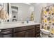 Bathroom featuring a dark wood vanity, white countertop, large mirror and a floral shower curtain at 30876 N 128Th Dr, Peoria, AZ 85383