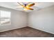 Empty bedroom with a ceiling fan, a window with blinds, and neutral colored walls and carpet at 30876 N 128Th Dr, Peoria, AZ 85383