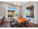 Bright dining room with wood table, chandelier, and backyard views at 30876 N 128Th Dr, Peoria, AZ 85383
