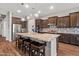 A large kitchen island featuring pendant lighting, seating, stainless appliances, and granite countertops at 30876 N 128Th Dr, Peoria, AZ 85383
