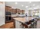 A large kitchen island featuring pendant lighting, seating, stainless appliances, and granite countertops at 30876 N 128Th Dr, Peoria, AZ 85383