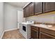 Well-equipped laundry room featuring a sink, overhead cabinets, and modern washer/dryer at 30876 N 128Th Dr, Peoria, AZ 85383